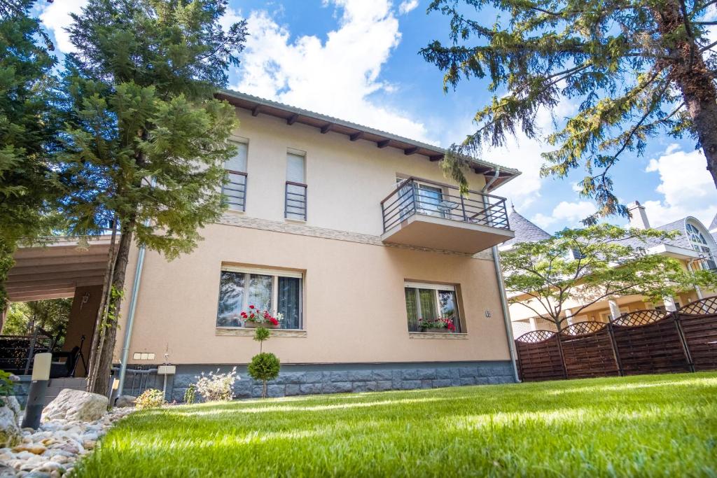 a house with a green yard in front of it at Vas Villa in Siófok