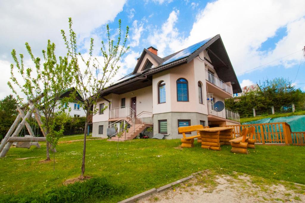 una casa con un albero di fronte di HELENOWO a Lutowiska