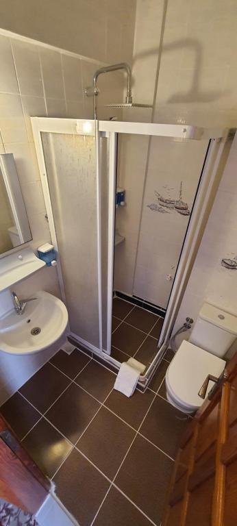 a bathroom with a shower and a toilet and a sink at Grand Yayla Hotel in Çeşme