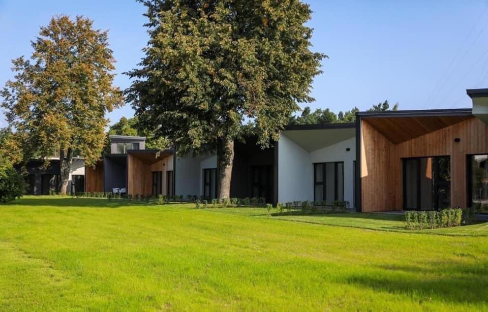 a view of a house with a large yard at Seaside bungalow Juura at Albatross, Kesterciems with garden, Spa and pool for extra in Ķesterciems