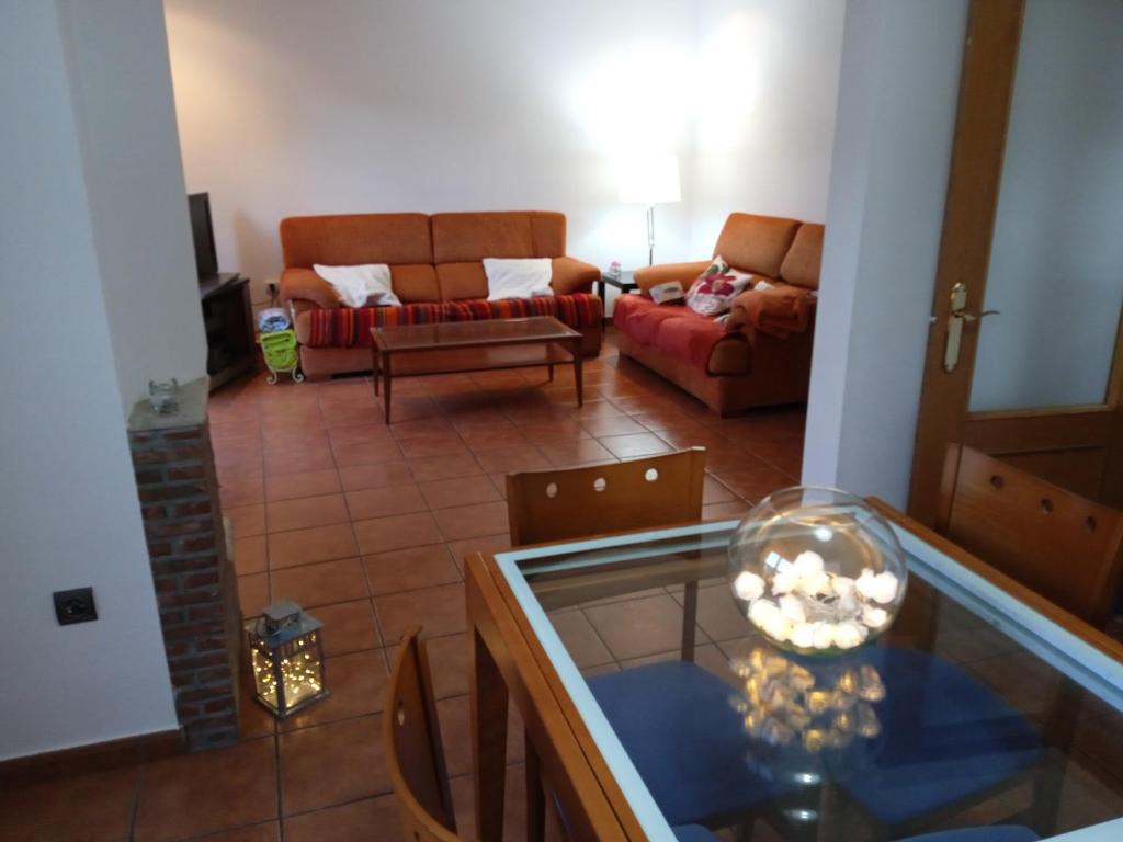 ein Wohnzimmer mit einem Sofa und einem Glastisch in der Unterkunft Vivienda adosada , con merendero en Carcedo in Carcedo de Burgos