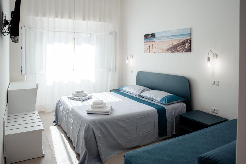 a bedroom with a bed with a blue head board at Torre del Salento in Torre San Giovanni Ugento