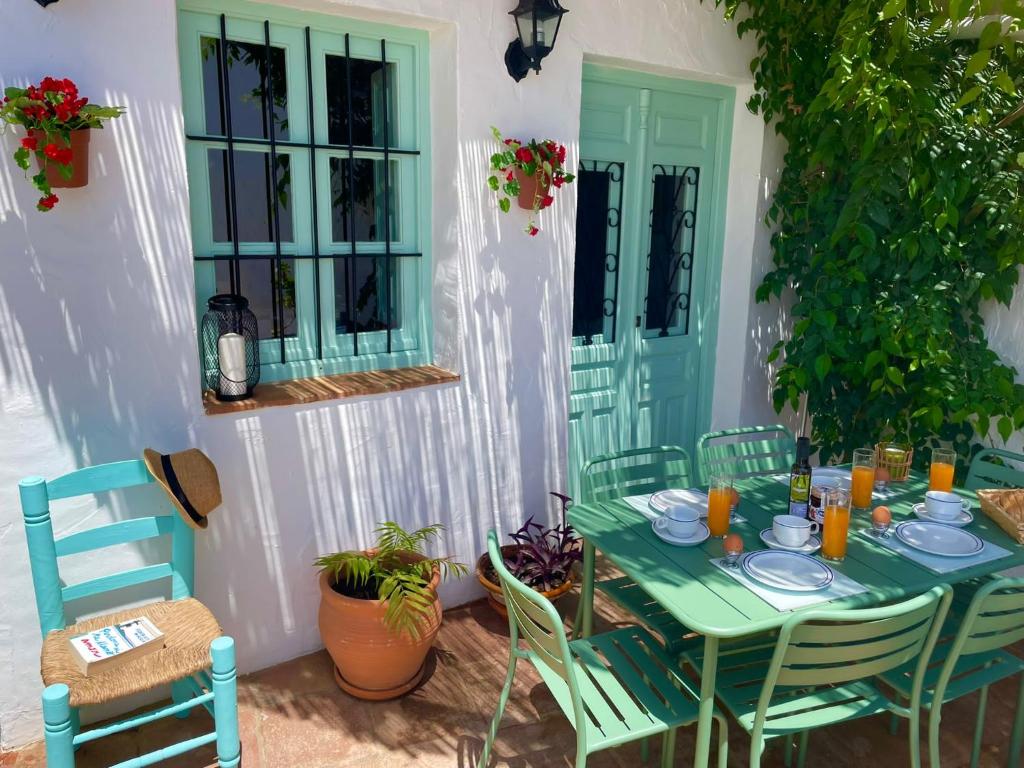 einen grünen Tisch und Stühle auf einer Terrasse in der Unterkunft Casa Salamanquesa in Ríogordo