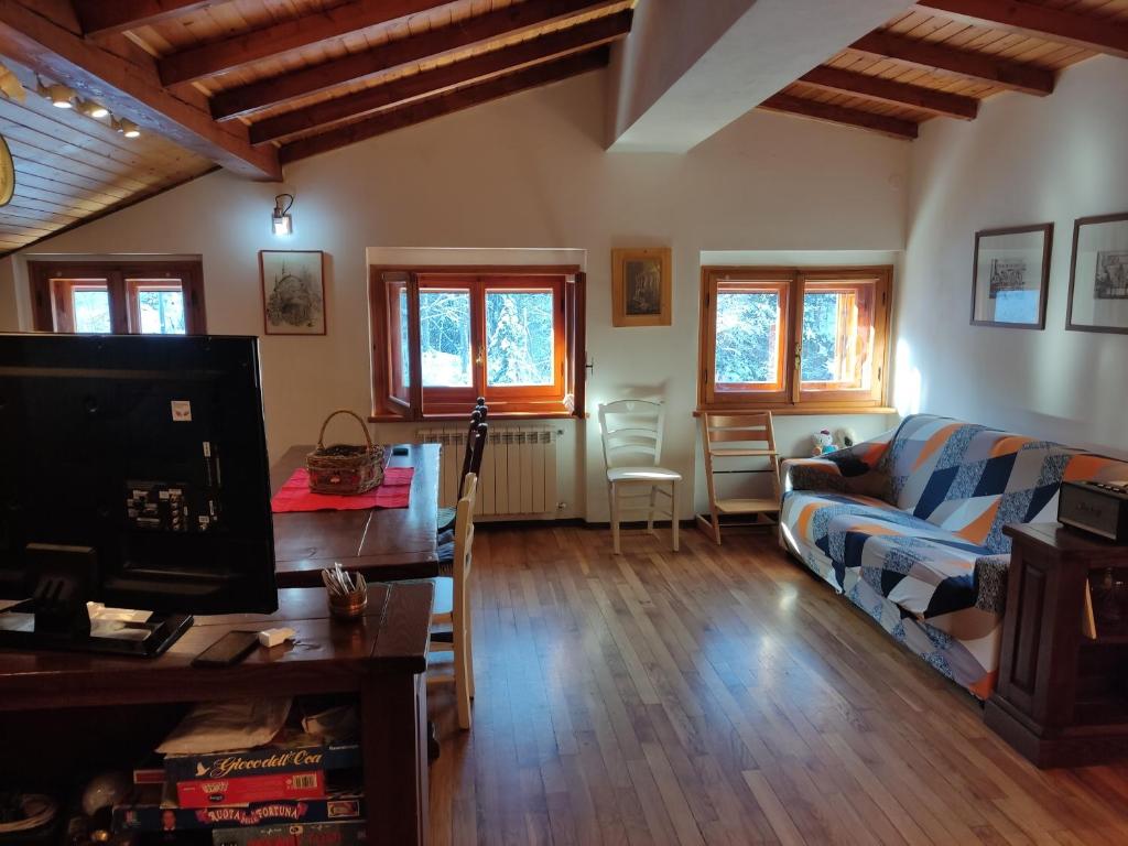 ein Wohnzimmer mit einem Sofa und einem TV in der Unterkunft Stefano Home Abetone in Abetone