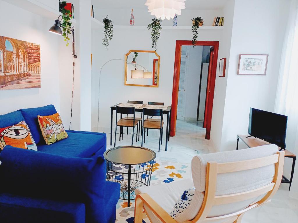 Palacio de Dueñas Private Terrace في إشبيلية: غرفة معيشة مع أريكة زرقاء وطاولة