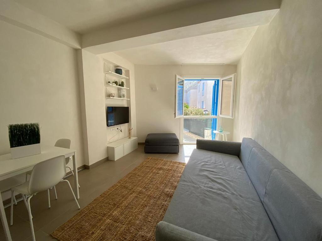 uma sala de estar com um sofá, uma mesa e uma secretária em Il Corallo em Marettimo