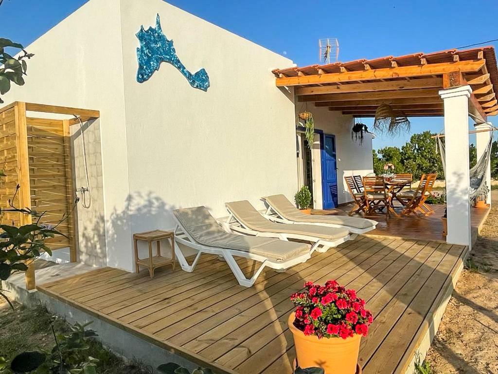 una terraza de madera con 2 sillas y una pérgola en CA NA CATALINA DEN ANDREU, en Sant Francesc Xavier