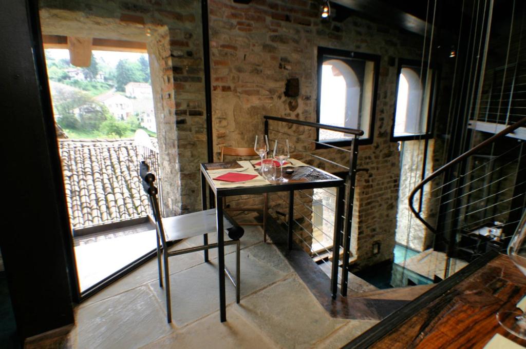 モンフォルテ・ダルバにあるLe Case della Saraccaのワイングラス付きのテーブルが備わる客室です。