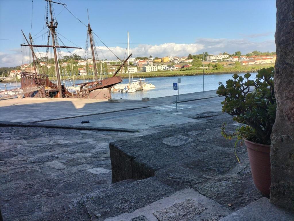 a boat docked in a marina with a ship in the water at Casa da Alfândega em Vila do Conde in Vila do Conde