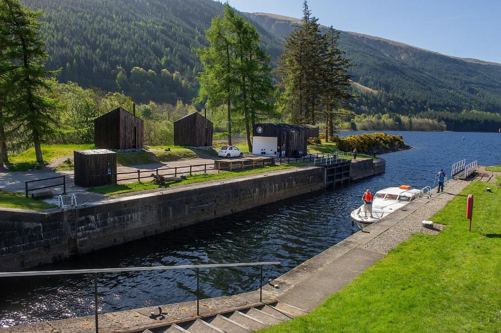 a boat is docked at a dock on a lake at Laggan Bothies in Spean Bridge