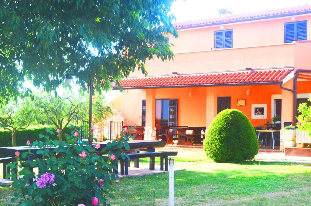an orange house with a picnic table in the yard at Rooms Danica in Poreč