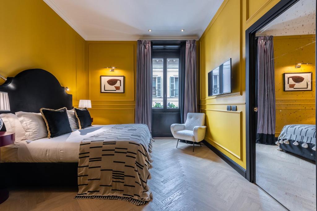 a bedroom with yellow walls and a bed and a chair at The Couper Sant'Andrea in Milan