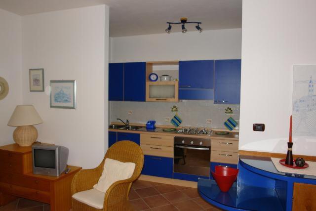a kitchen with blue cabinets and a table and chairs at Casa Roberta in Alghero