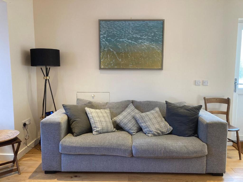 uma sala de estar com um sofá azul com almofadas em Coach house Harrogate em Harrogate