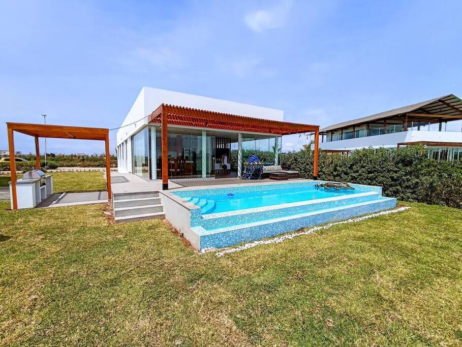 a house with a swimming pool in the yard at HOP ODAIBA exclusiva laguna y playa en Chincha in Chincha Baja