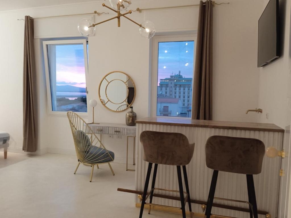 a kitchen with two chairs and a table and a mirror at Casa Allegri in Alghero