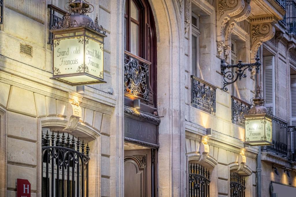 un edificio con dos relojes a un lado. en Best Western Grand Hotel Francais en Burdeos