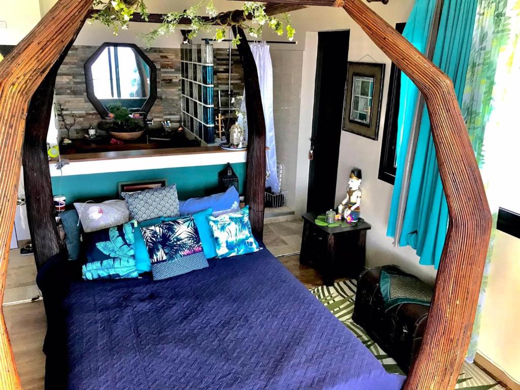 1 dormitorio con 1 cama con dosel de madera en La novia Del Mar un Cocon entre Ciel et Mer, en Saint-Pierre