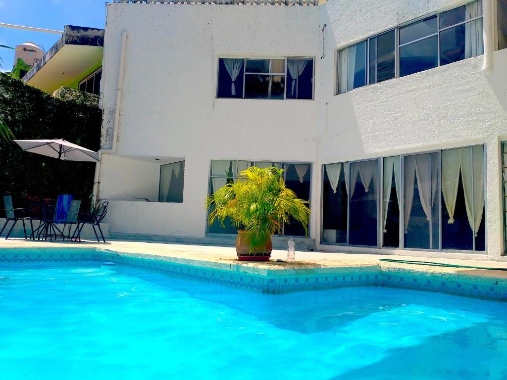 a swimming pool in front of a house at casa HIKURI in Cancún