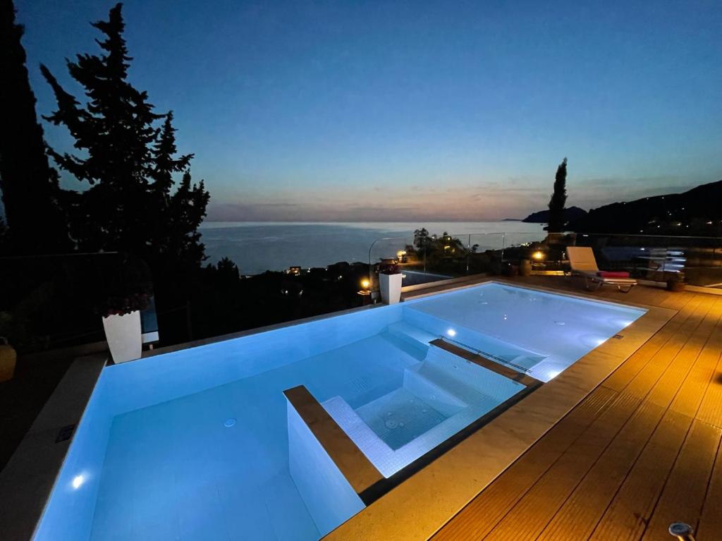 a blue swimming pool on a deck at night at Casa Tramonto Beach View Agios Gordios Corfu in Agios Gordios