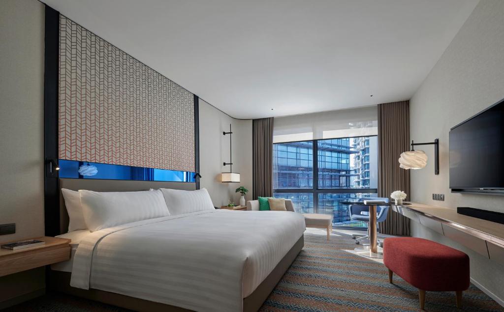 a hotel room with a large bed and a television at Amari Kuala Lumpur in Kuala Lumpur