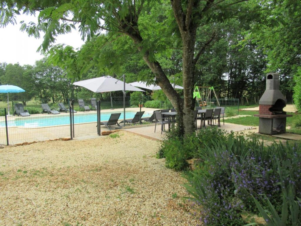 a pool with a table and chairs and a tree at Gîte Mauzens-et-Miremont, 6 pièces, 10 personnes - FR-1-616-254 in Mauzens-et-Miremont