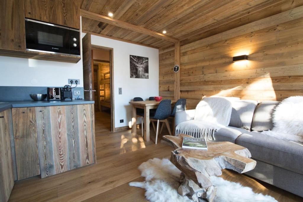 ein Wohnzimmer mit einem Sofa und einem Tisch in der Unterkunft Les Brigues - Appartement avec vue sur la montagne et accès aux pistes in Courchevel