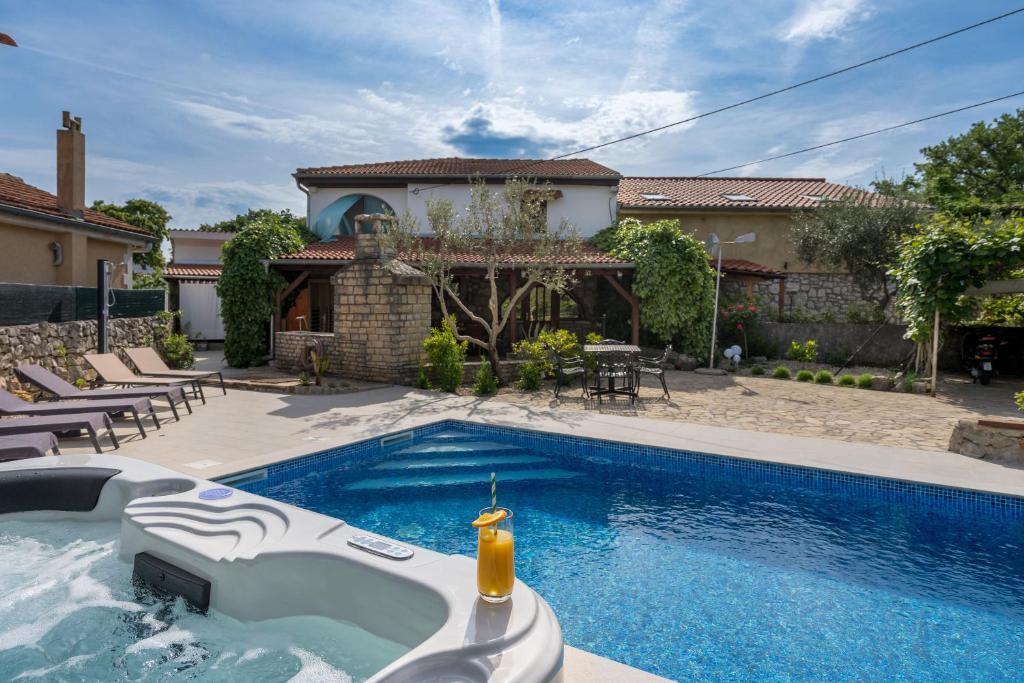 a swimming pool in front of a house at House Stone Lady in Dobrinj