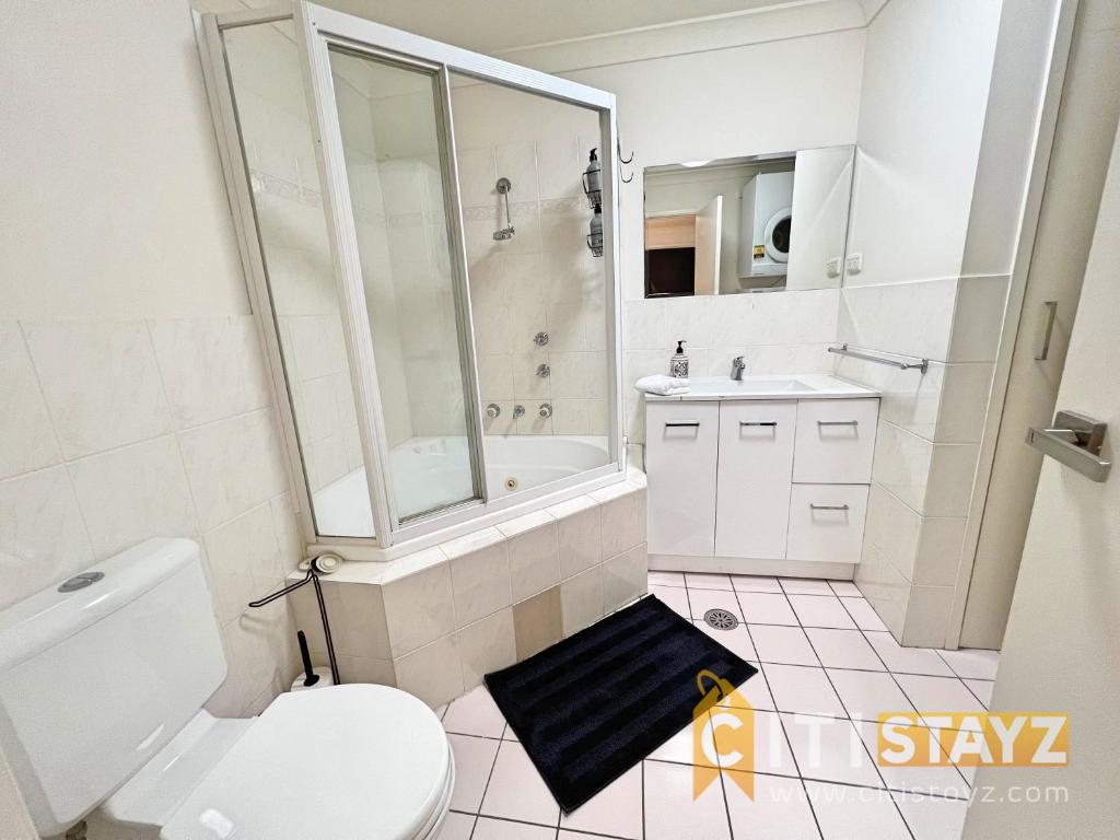 a white bathroom with a shower and a toilet at Beautiful & enclosed, 1 bd 1 bth - close to CBR Hospital in Phillip