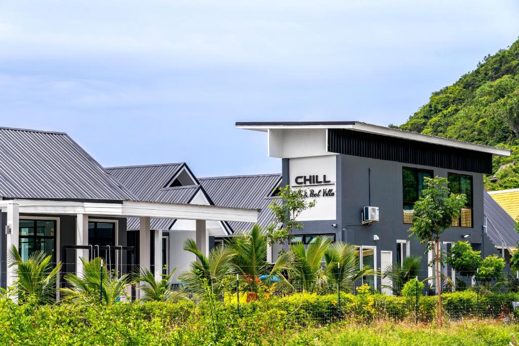 a building with a hill in the background at The Chill Villa Prachuap in Khao Khan Kradaj