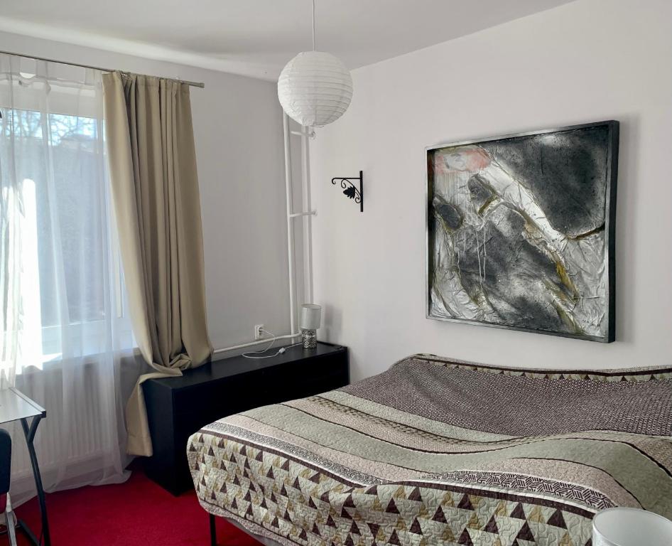 een slaapkamer met een bed en een schilderij aan de muur bij Perfect location two bedrooms with balkony in Warschau