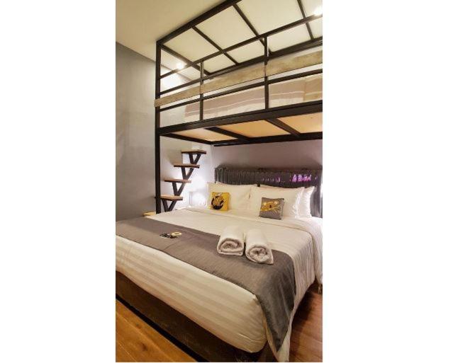 a bedroom with a bunk bed with two towels on it at Nine Hotel in Palembang