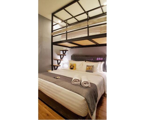 1 dormitorio con litera y 2 toallas en Nine Hotel, en Palembang