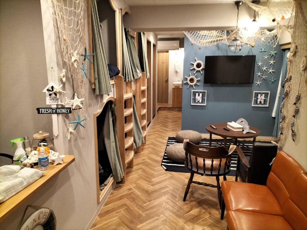 a living room with a couch and a table at bnb plus Ueno Park Female only in Tokyo