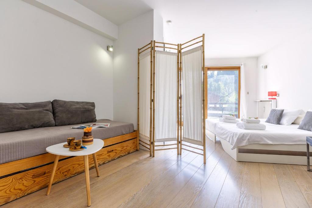 een woonkamer met een bank, een bed en een tafel bij Le Bellevue 04 - Happy Rentals in Chamonix-Mont-Blanc