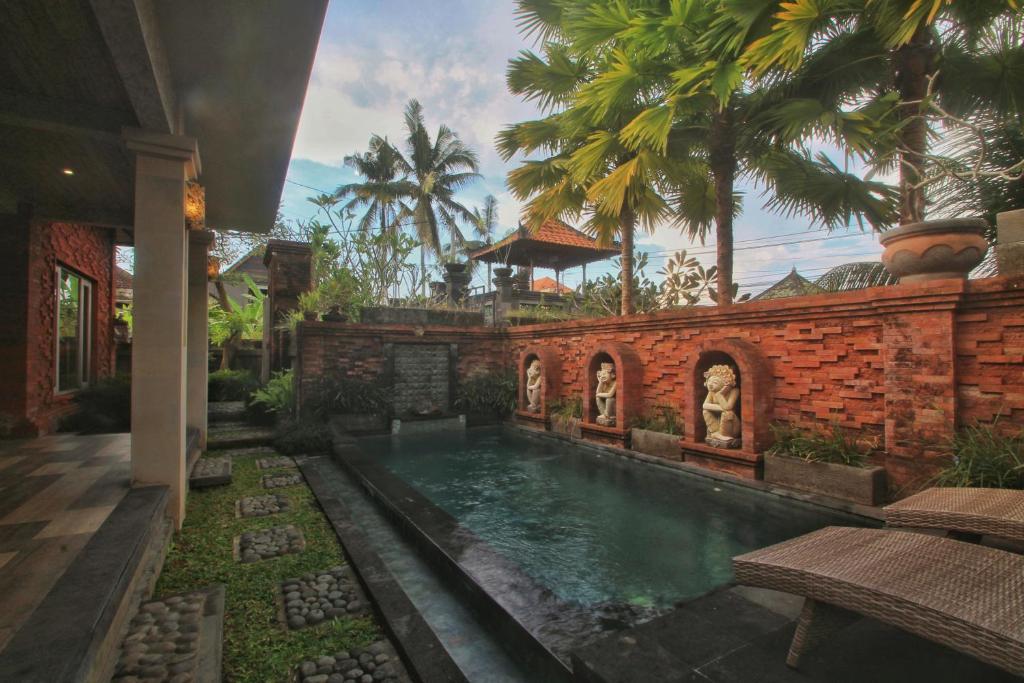 een huis met een zwembad in een tuin bij The Suci Sari Ubud in Ubud
