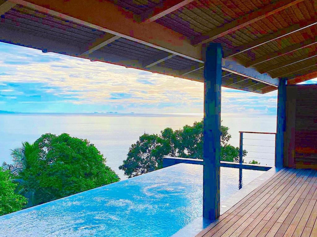 a view of the ocean from a balcony of a house at Bella & Palma Villas in Haad Tian