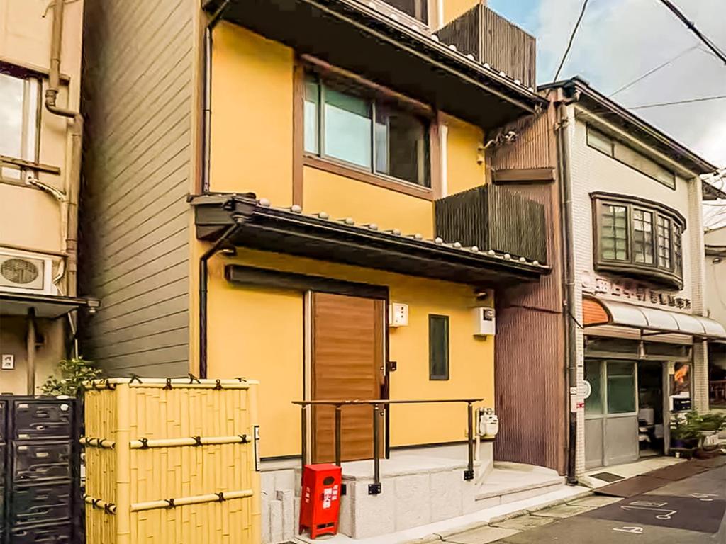 a yellow house with a gate in front of it at 慶有魚·八坂(Kyotofish·Yasaka)*近清水寺祗园5分钟*庭院地暖浴缸*京都民宿认证 in Kyoto