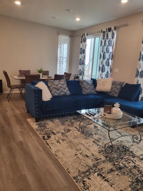 a living room with a blue couch and a glass table at Nile Haven in Aurora