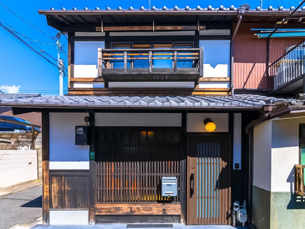 a building with a wooden door and a balcony at 慶有魚·二条城(Kyotofish·Nijojo)*百年町屋青石板*庭院浴缸*二条站6分钟*民宿认证 in Kyoto