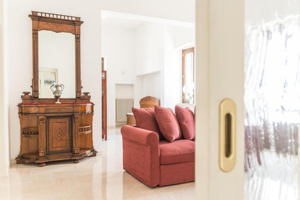a living room with a red couch and a mirror at Casa Sampietro in Locorotondo