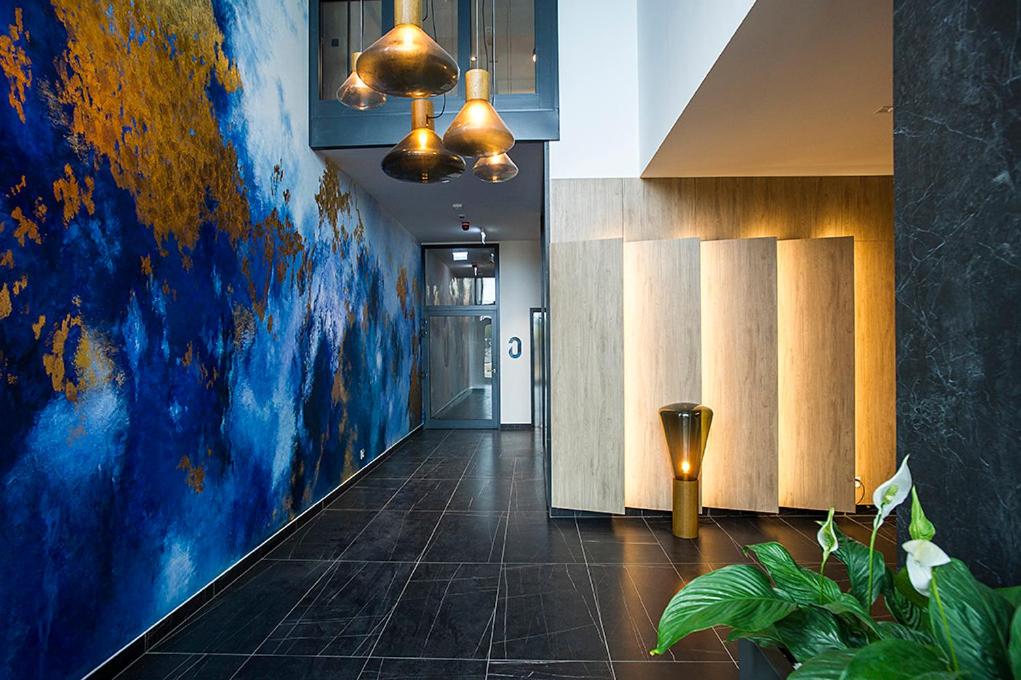 a hallway with a large painting on the wall at MustSEA Gdańsk Apartments with underground parking in Gdańsk