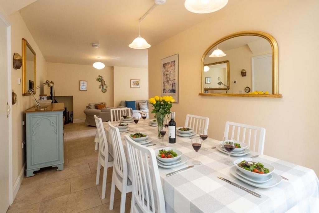 Willow House في Aldringham: غرفة طعام مع طاولة مع كراسي بيضاء