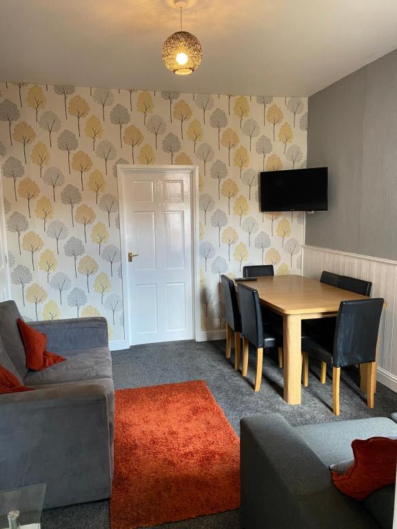 a living room with a table and chairs and a television at Freya House in Gainsborough