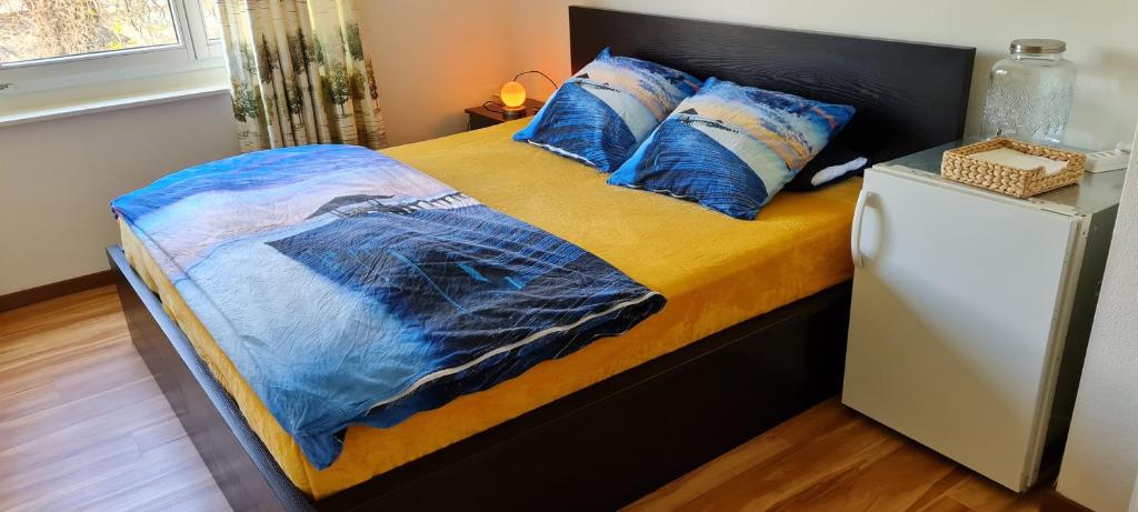 een bed met een blauw dekbed en kussens erop bij Glatthall Premium in Opfikon