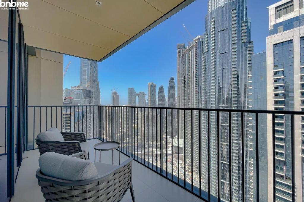 een balkon met stoelen en uitzicht op de stad bij bnbmehomes - Breathtaking Downtown Views at BLVD - 3801 in Dubai