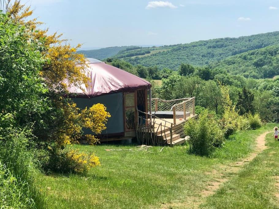 um gazebo num campo ao lado de um caminho em Yourte 2-4 personnes avec SPA em Saint-Laurent-de-Lévézou