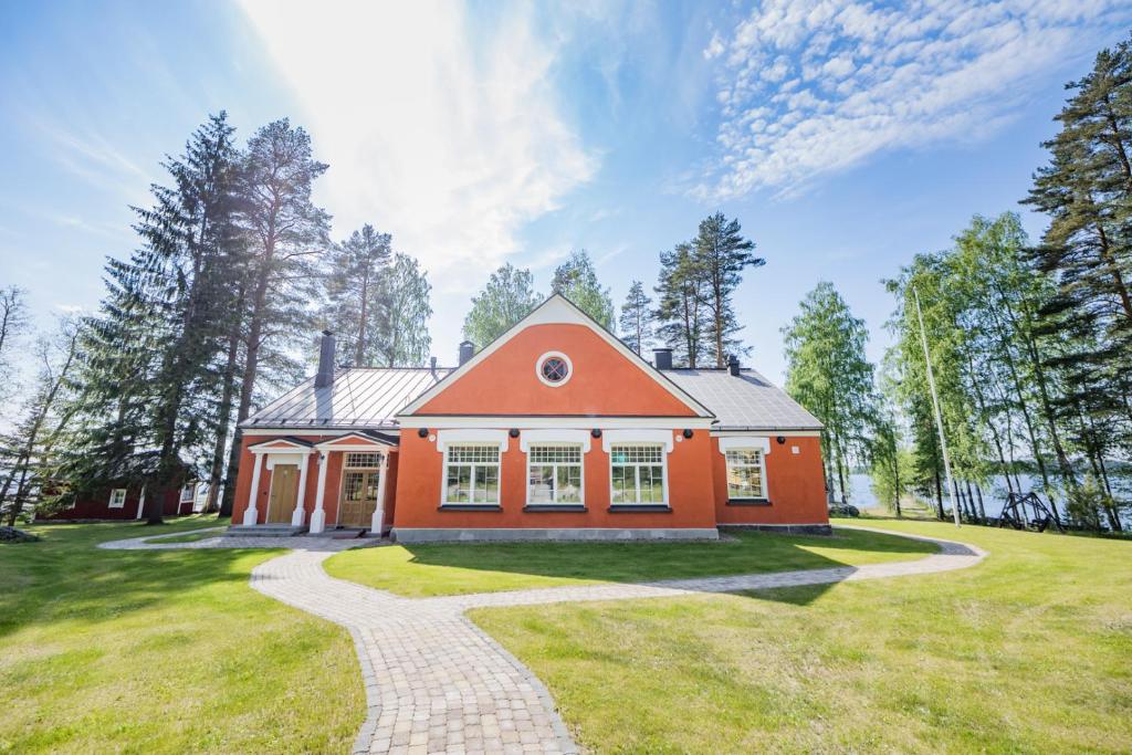 uma casa cor-de-laranja com um caminho que leva até ela em B&B Taipaleenniemi em Savonlinna
