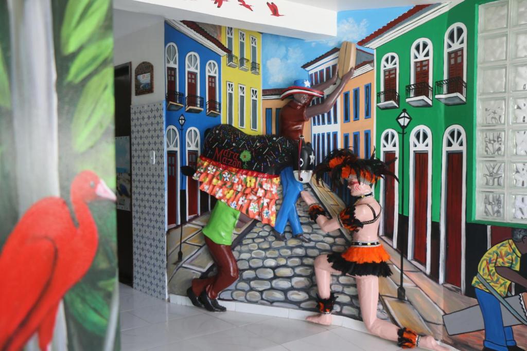 a mural of two people standing in a street at Pousada Maramazon in São Luís