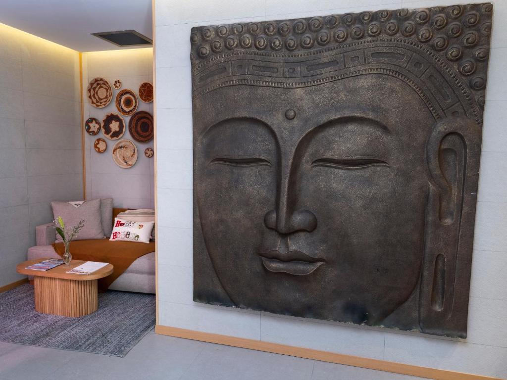a large metal face on a wall in a room at Sa'Rezya Hotel in Çeşme